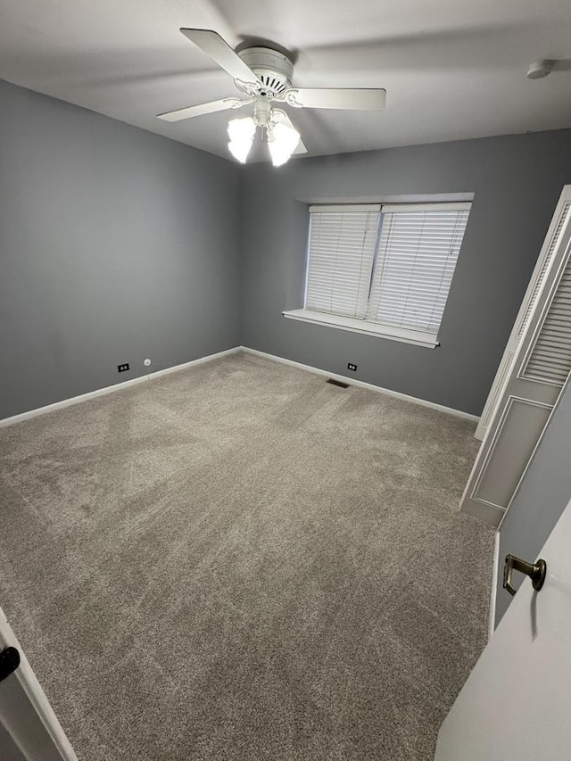 spare room featuring carpet and ceiling fan