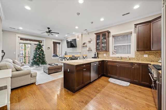 kitchen featuring ceiling fan, light hardwood / wood-style flooring, kitchen peninsula, crown molding, and appliances with stainless steel finishes