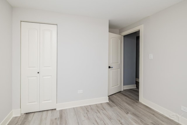 unfurnished bedroom with light hardwood / wood-style floors and a closet