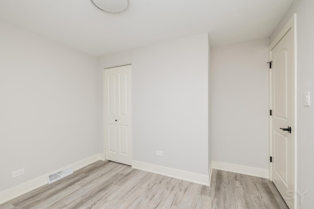 empty room with light hardwood / wood-style flooring