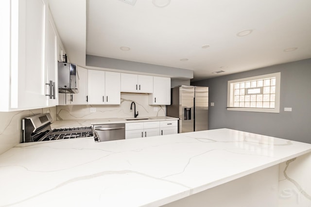 kitchen featuring kitchen peninsula, sink, white cabinets, and appliances with stainless steel finishes