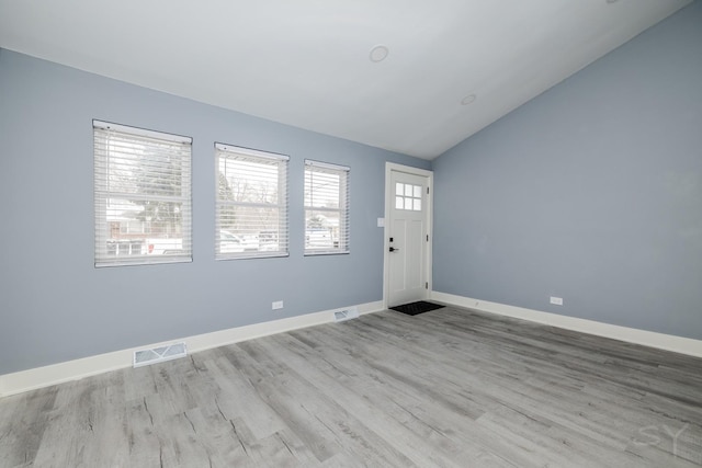 entryway with light hardwood / wood-style floors and lofted ceiling