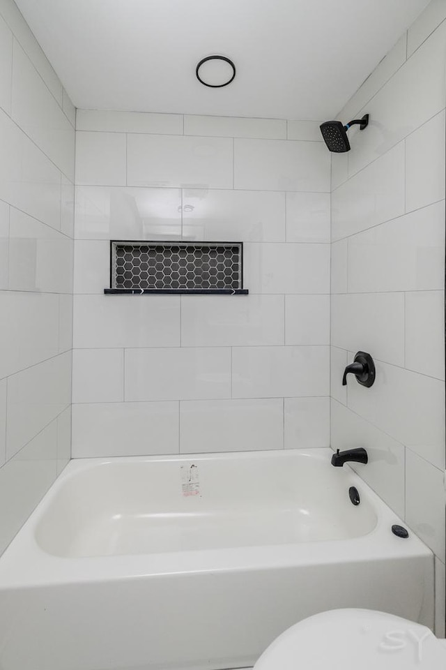 bathroom with tiled shower / bath and toilet