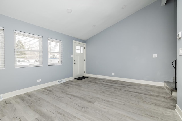 foyer with light wood-type flooring and lofted ceiling