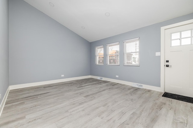 entryway with light hardwood / wood-style floors and lofted ceiling