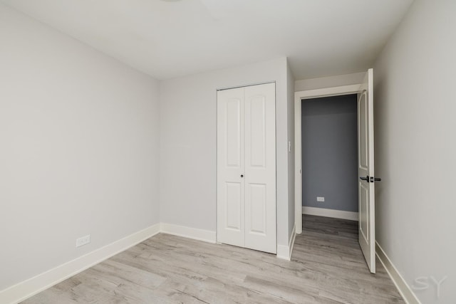 unfurnished bedroom with light hardwood / wood-style floors and a closet