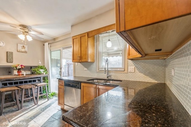 kitchen featuring sink, ceiling fan, stainless steel dishwasher, decorative backsplash, and hanging light fixtures