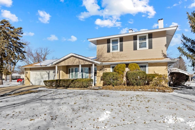 traditional-style home featuring brick siding, driveway, a chimney, and an attached garage