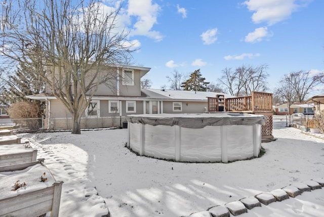 snow covered back of property featuring a swimming pool side deck