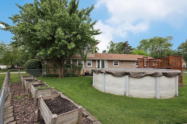 1141 Hartford Ln, Elk Grove Village, IL 60007 - view of grassy yard with a vegetable garden, central AC unit, and a wooden deck