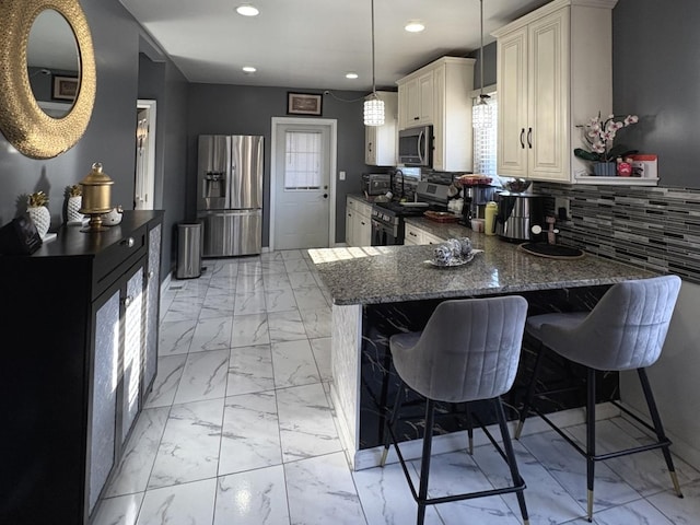 kitchen with a breakfast bar, hanging light fixtures, decorative backsplash, dark stone countertops, and appliances with stainless steel finishes