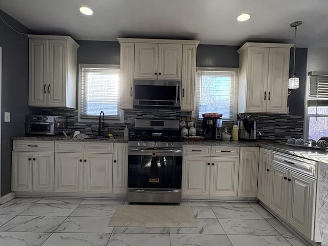 kitchen with a wealth of natural light, decorative backsplash, dark stone countertops, and stainless steel appliances