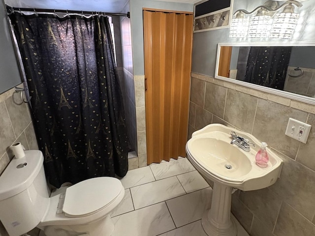 bathroom with curtained shower, tile walls, and toilet