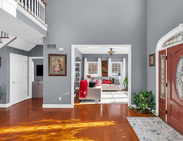 foyer with hardwood / wood-style flooring and high vaulted ceiling