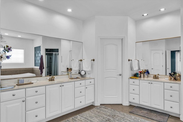 bathroom featuring plus walk in shower, tile patterned flooring, and vanity