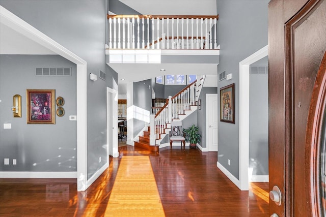 foyer entrance featuring a high ceiling and wood-type flooring