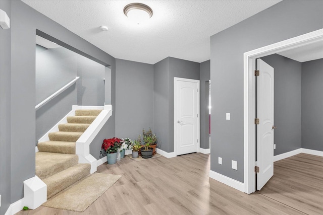 foyer with light hardwood / wood-style floors and a textured ceiling