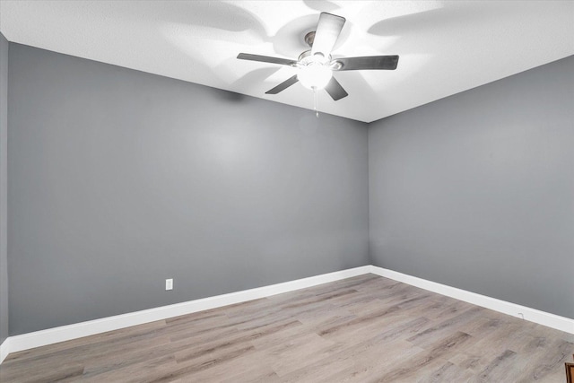 empty room featuring ceiling fan, light hardwood / wood-style flooring, and a textured ceiling