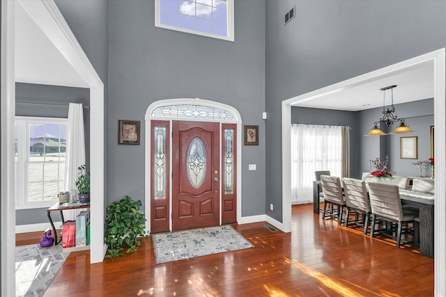 entryway featuring dark wood-type flooring and a towering ceiling