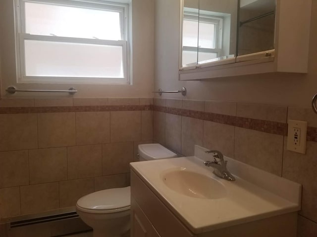 bathroom featuring a baseboard radiator, plenty of natural light, vanity, and toilet