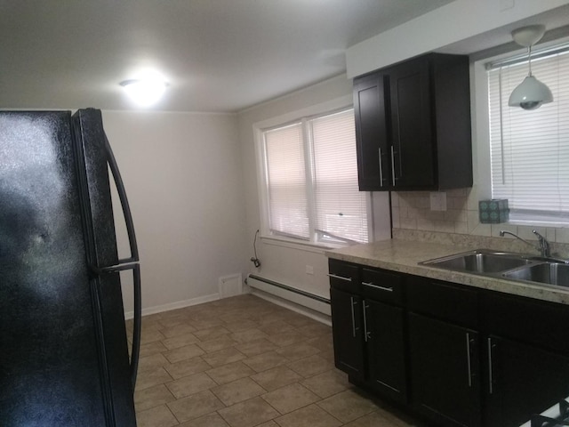 kitchen featuring sink, black fridge, tasteful backsplash, decorative light fixtures, and a baseboard radiator