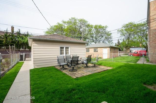 rear view of property featuring a patio and a lawn