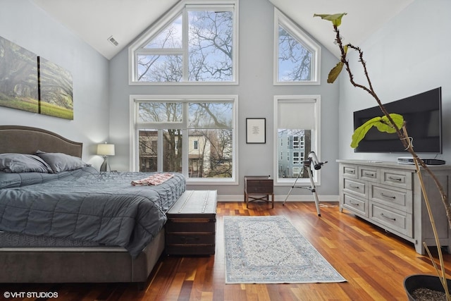 bedroom with hardwood / wood-style floors and high vaulted ceiling