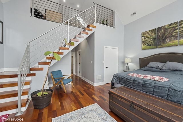 bedroom featuring dark hardwood / wood-style flooring and high vaulted ceiling