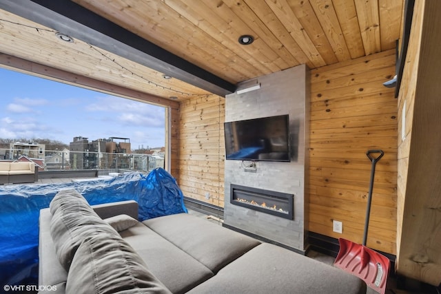 living room with beamed ceiling, a large fireplace, wood ceiling, and wood walls