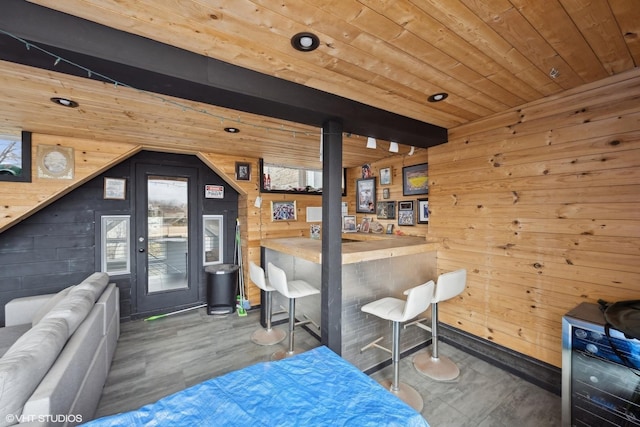 interior space with indoor bar, access to outside, wooden ceiling, and wood walls