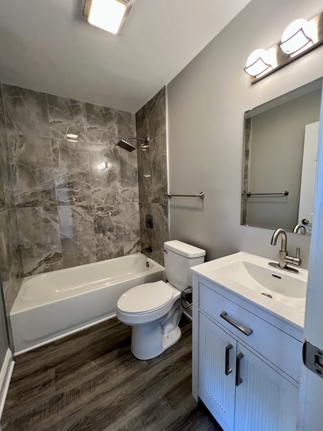 full bathroom with vanity, hardwood / wood-style floors, tiled shower / bath combo, and toilet