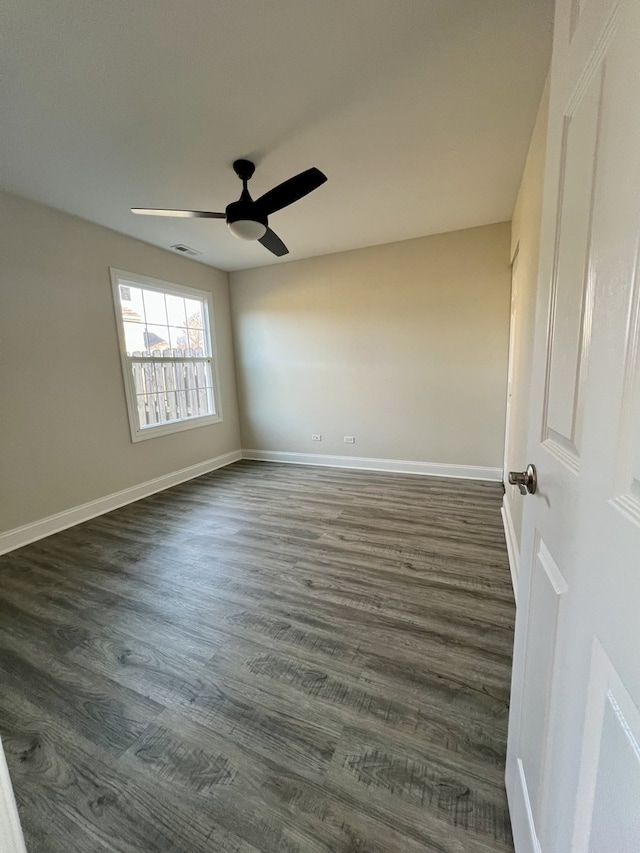 empty room featuring ceiling fan and dark wood-type flooring