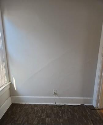 unfurnished room with baseboards