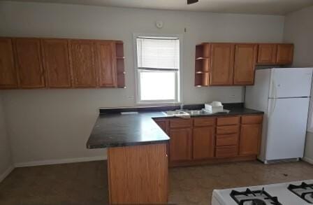 kitchen featuring open shelves, dark countertops, brown cabinets, and white appliances