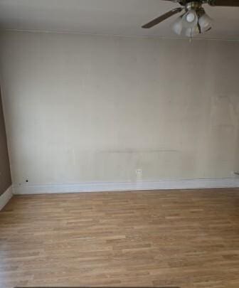 unfurnished room featuring wood finished floors, baseboards, and ceiling fan