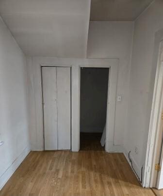 unfurnished bedroom featuring light wood-style floors and a closet