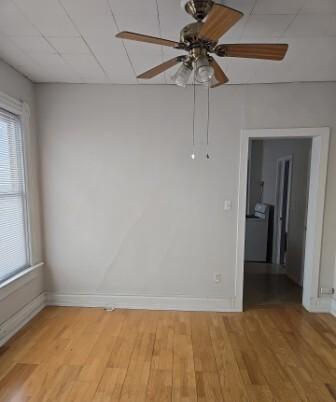 spare room with baseboards and light wood finished floors