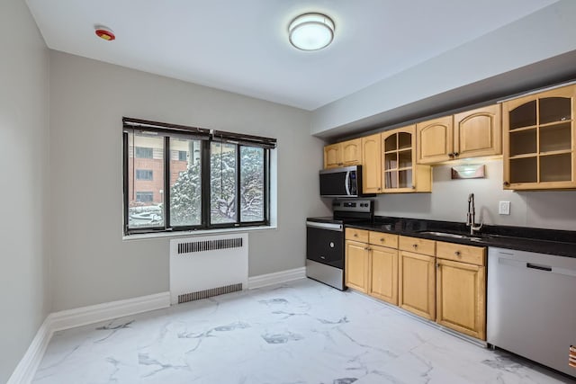 kitchen featuring light brown cabinetry, stainless steel appliances, radiator, and sink