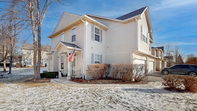 view of snowy exterior featuring a garage