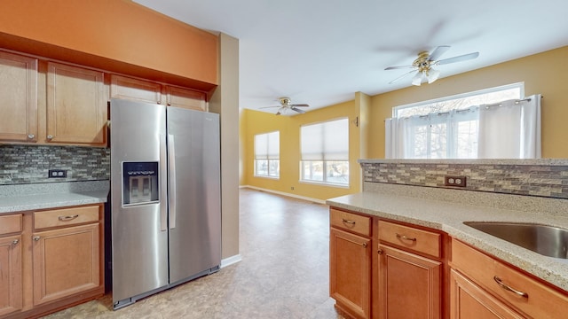 kitchen featuring ceiling fan, stainless steel fridge, sink, and decorative backsplash