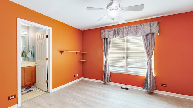 unfurnished room with a wealth of natural light, ceiling fan, and light wood-type flooring