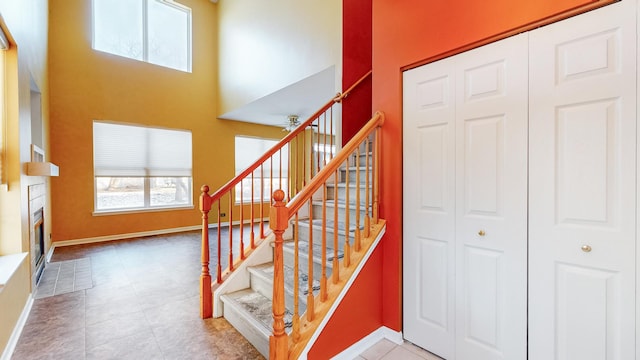 stairway featuring tile patterned flooring and a high ceiling