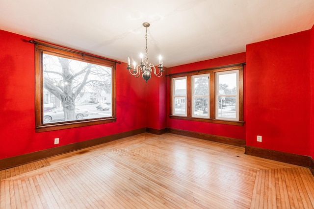 unfurnished dining area featuring a notable chandelier and light hardwood / wood-style flooring