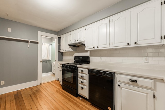 kitchen with decorative backsplash, light wood-type flooring, white cabinetry, and black appliances