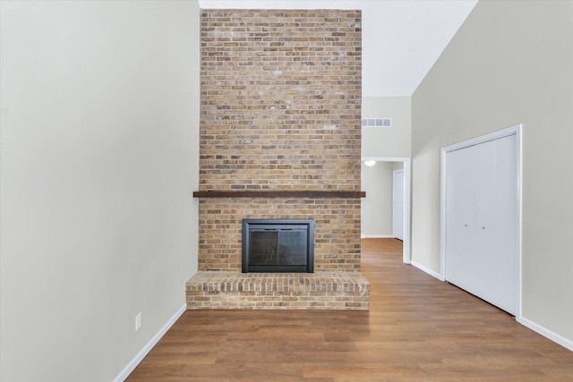 unfurnished living room with hardwood / wood-style flooring and a fireplace