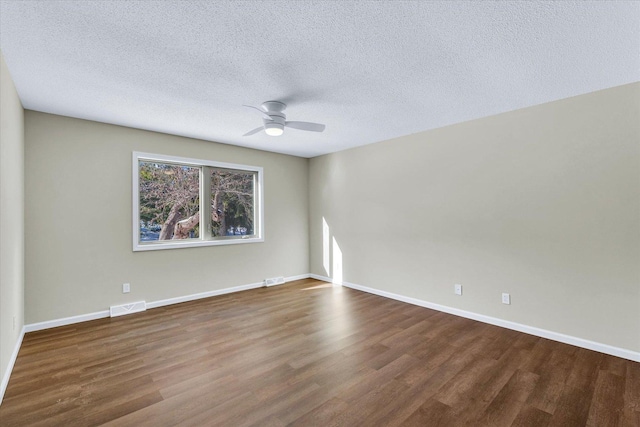 unfurnished room with dark wood-type flooring, ceiling fan, and a textured ceiling