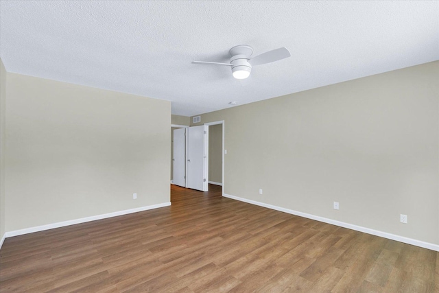 empty room featuring hardwood / wood-style flooring, a textured ceiling, and ceiling fan