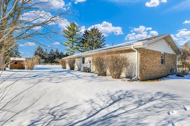 view of snowy exterior with central AC unit