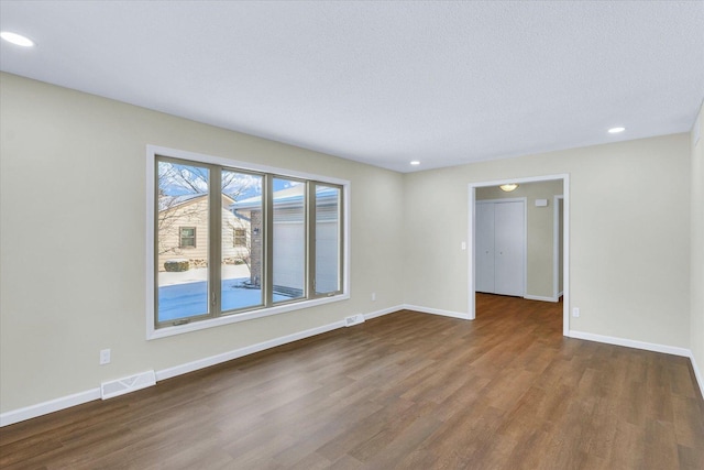 empty room featuring dark hardwood / wood-style flooring and a textured ceiling