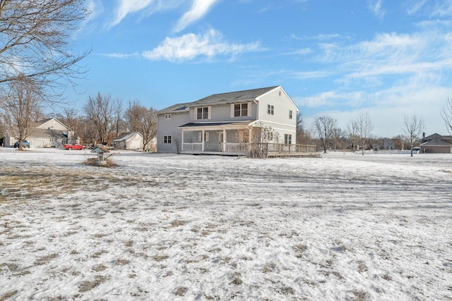 snow covered property with covered porch